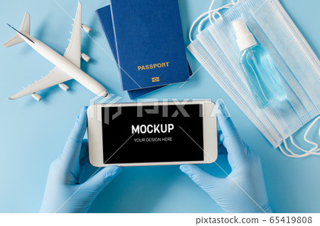 Travel and Tourism Planning after Quarantine. Smartphone with airplane model, passports, face mask 65419808