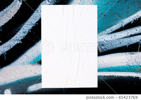 close up of colorful messy painted urban wall texture with wrinkled glued poster template  65423769