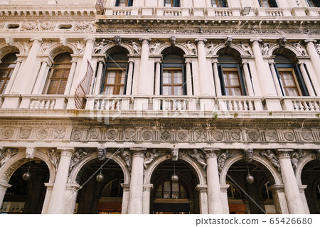 Building Fondazione Musei Civici di Venezia in Venice, Italy. Stone bas-reliefs on the facade of building in Piazza San Marco, classic Venetian windows, columns, balconies with small columns, stucco. 65426680
