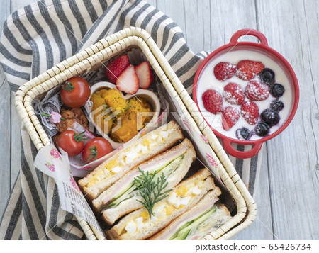 Lunch box with handmade sandwich and side dish in a basket, yogurt dessert 65426734