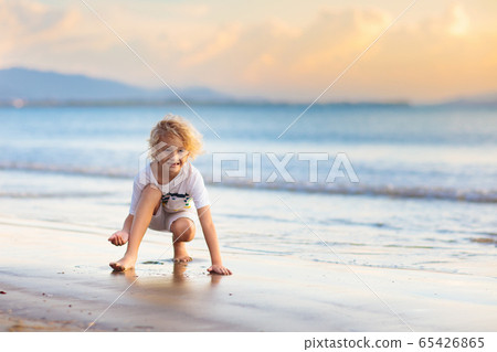 Kids play on tropical beach. Sand and water toy. 65426865