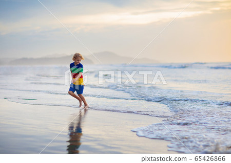 Child playing on ocean beach. Kid at sunset sea. Child playing on ocean beach. Kid at sunset sea. 65426866