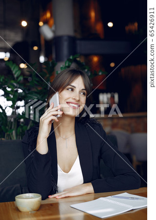 Businesswoman sitting at the table in a cafe and working 65426911