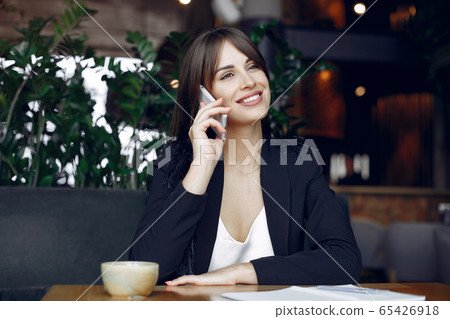Businesswoman sitting at the table in a cafe and working 65426918