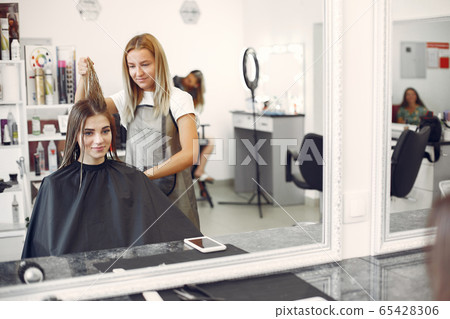 Woman drying hair in a hairsalon 65428306