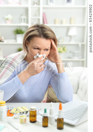 Beautiful young woman with pills using laptop Beautiful young woman with pills using laptop 65429902