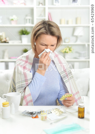 Portrait of beautiful young woman with pills 65429969