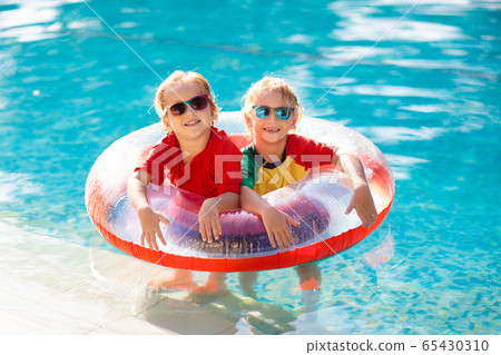 Kids in swimming pool. Life jacket for child. 65430310