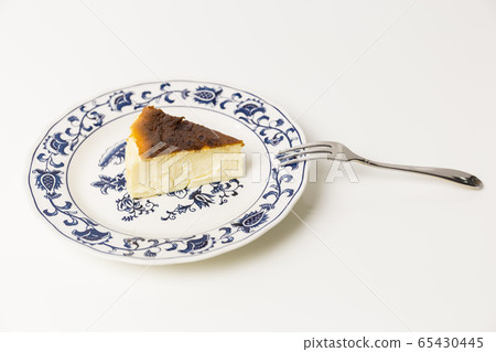 Basque Burnt Cheesecake with fork isolated in white background. 65430445