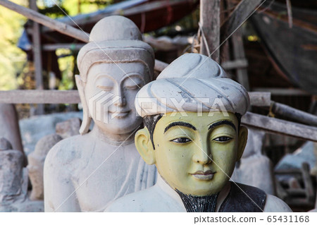 carving Buddha statues from stone in a street carving Buddha statues from stone in a street 65431168