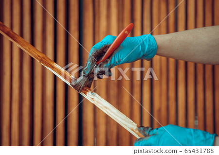 varnishing of wooden slats with a protective coating with a color shade 65431788