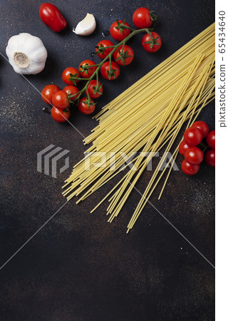 spaghetti, tomato and garlic on the black table spaghetti, tomato and garlic on the black table 65434640
