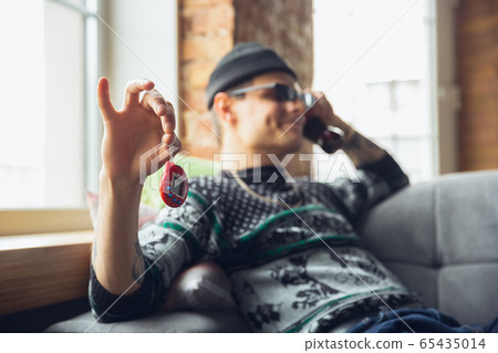Portrait of millenial boy using retro toys, meeting things from the past and having fun, exploring tamagotchi, virtual pet game Portrait of millenial boy using retro toys, meeting things from the past and having fun, exploring tamagotchi, virtual pet game 65435014