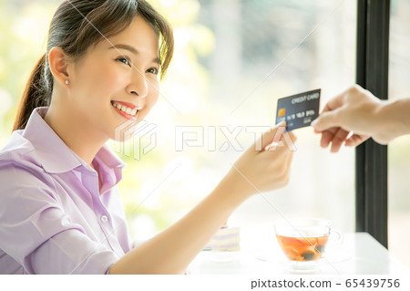 年輕漂亮的女人咖啡館付款信用卡業務員交出材料 年輕漂亮的女人咖啡館付款信用卡業務員交出材料 65439756