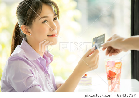 年輕漂亮的女人咖啡館付款信用卡業務員交出材料 年輕漂亮的女人咖啡館付款信用卡業務員交出材料 65439757