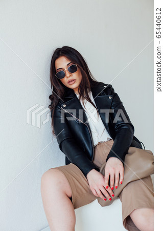 Beautiful fashionable eastern brunette woman in black leather jacket Beautiful fashionable eastern brunette woman in black leather jacket 65440612