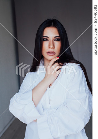 Beautiful fashionable eastern brunette woman in white shirt Beautiful fashionable eastern brunette woman in white shirt 65440692