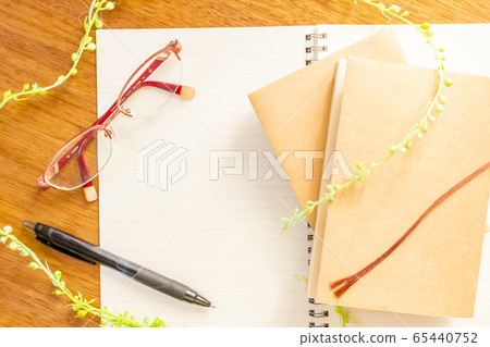 Overlooking the notebook, pen, book and glasses on the table 65440752