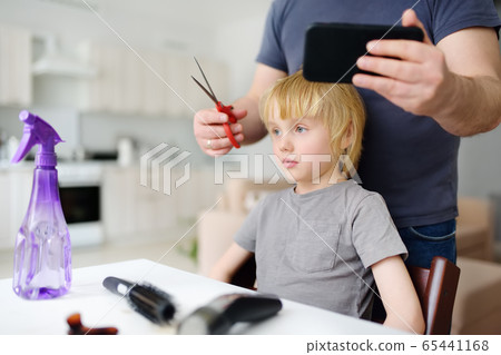 Preschooler boy gets haircut at home during quarantine. Preschooler boy gets haircut at home during quarantine. 65441168