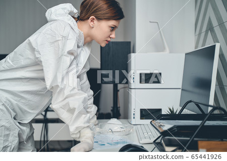 Beautiful lady in protective suit using computer at work 65441926