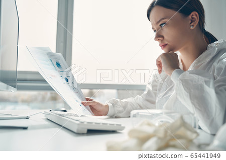 Charming lady analyzing patient data and current indicators Charming lady analyzing patient data and current indicators 65441949
