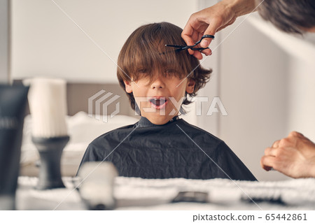 Little child looking surprised sitting at the table Little child looking surprised sitting at the table 65442861