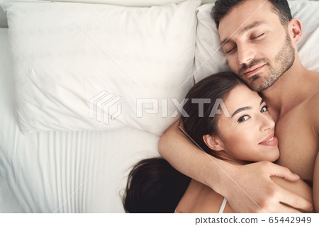 Young man hugging his wife during sleep 65442949