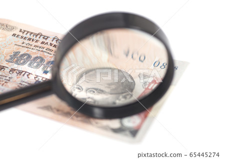 Indian Currency Rupee Note with magnifying glass 65445274