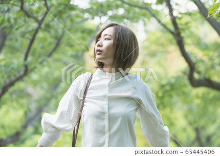 A woman relaxing in a green park 65445406