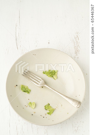Food leftovers on dirty plate after finished salad 65446367