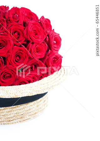 Luxury red roses in straw hat on white. Romantic gift for girl or woman. Copy space Luxury red roses in straw hat on white. Romantic gift for girl or woman. Copy space 65446851