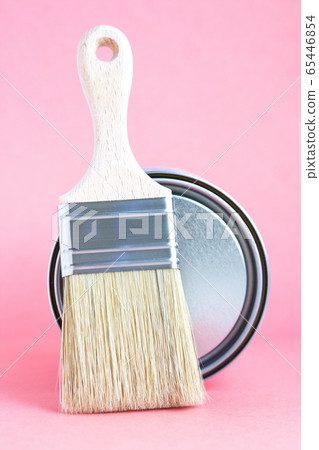 Paint metal can and new brush on pink background. Focus on brush. House renovation. Hobby. Color therapy Paint metal can and new brush on pink background. Focus on brush. House renovation. Hobby. Color therapy 65446854