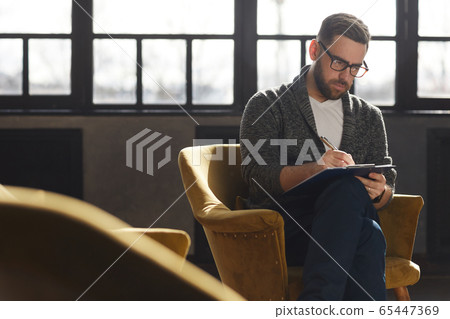 Man writing in document Man writing in document 65447369