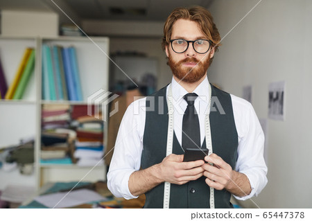 Designer using mobile phone 65447378