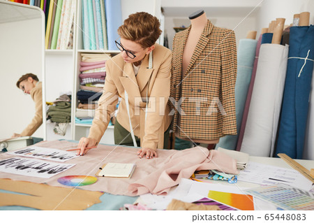 Fashion designer working with sketches Fashion designer working with sketches 65448083