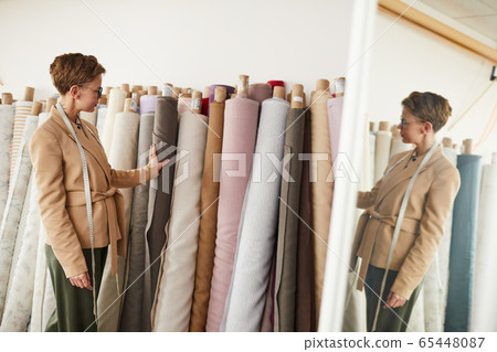 Designer looking at modern textile Designer looking at modern textile 65448087