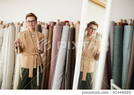 Fashion designer working with textile in workshop 65448089