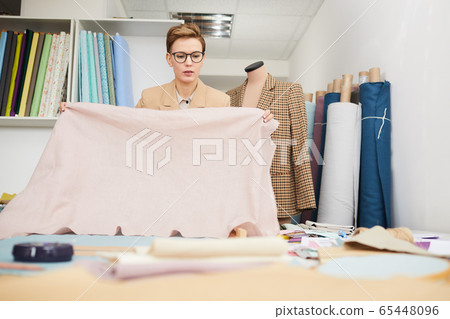 Designer working with fabric for new collection 65448096