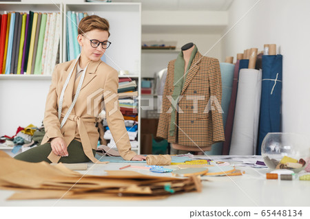 Tailor working with patterns Tailor working with patterns 65448134