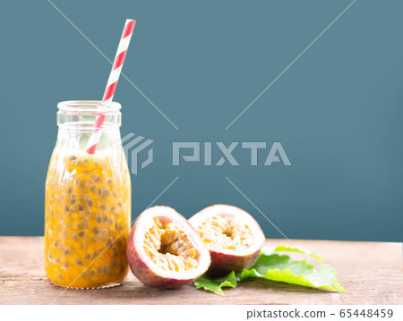 Glass bottle of passion fruit juice wood table Glass bottle of passion fruit juice wood table 65448459