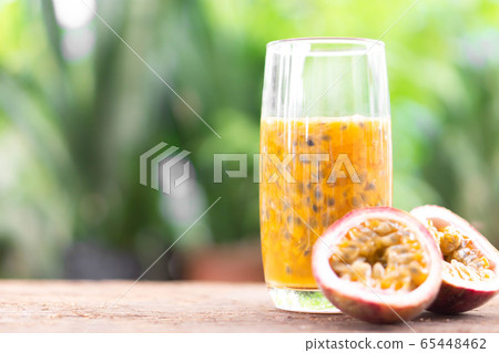 Glass of passion fruit juice wood table with green Glass of passion fruit juice wood table with green 65448462