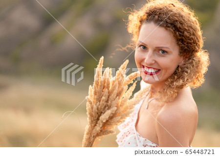 Beautiful tender girl in a white sundress walks at Beautiful tender girl in a white sundress walks at 65448721