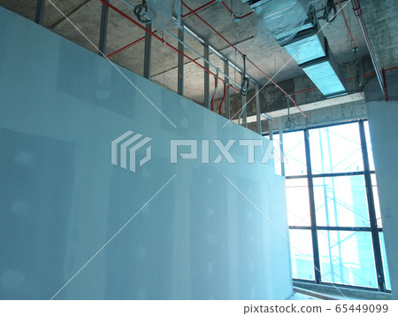 KUALA LUMPUR, MALAYSIA -APRIL 12, 2018: Drywall installation work in progress by construction workers at the construction site. It is the easiest and cheapest way to do partition for an interior wall. KUALA LUMPUR, MALAYSIA -APRIL 12, 2018: Drywall installation work in progress by construction workers at the construction site. It is the easiest and cheapest way to do partition for an interior wall. 65449099