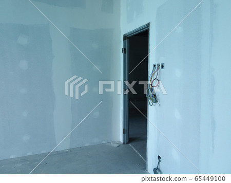 KUALA LUMPUR, MALAYSIA -APRIL 12, 2018: Drywall installation work in progress by construction workers at the construction site. It is the easiest and cheapest way to do partition for an interior wall. KUALA LUMPUR, MALAYSIA -APRIL 12, 2018: Drywall installation work in progress by construction workers at the construction site. It is the easiest and cheapest way to do partition for an interior wall. 65449100
