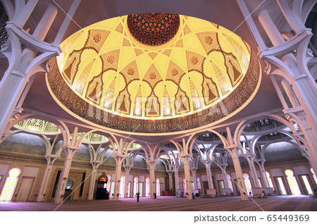 SARAWAK, MALAYSIA -OCTOBER 14, 2014: The interior of Sarawak State Mosque. The mosque has one big main prayer hall covered with one big and beautiful dome and supported with other small domes. SARAWAK, MALAYSIA -OCTOBER 14, 2014: The interior of Sarawak State Mosque. The mosque has one big main prayer hall covered with one big and beautiful dome and supported with other small domes. 65449369