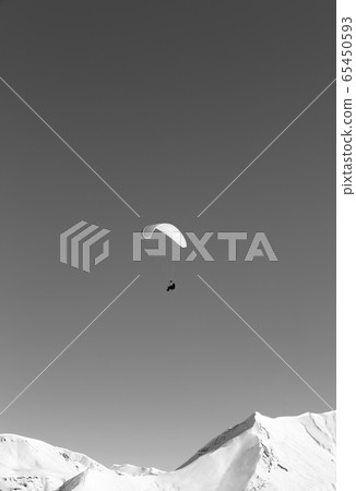 Paraglider in snowy winter mountains at sun day Paraglider in snowy winter mountains at sun day 65450593
