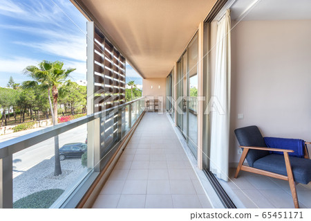 A modern, long corridor located outside the house, hotel, overlooking the street. 65451171