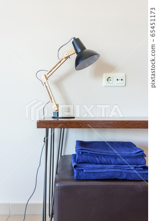 Modern design, interior room in the house, hotel with a lamp on the table, on towels 65451173