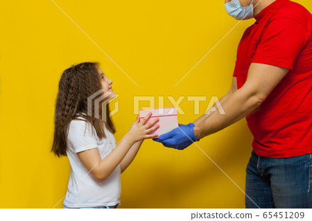 Child girl accepting a delivery of box from Child girl accepting a delivery of box from 65451209