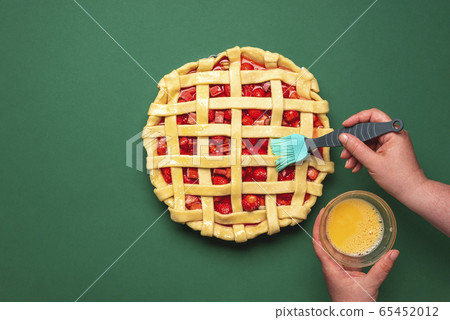 Making a strawberries tart. Greasing with egg yolk Making a strawberries tart. Greasing with egg yolk 65452012